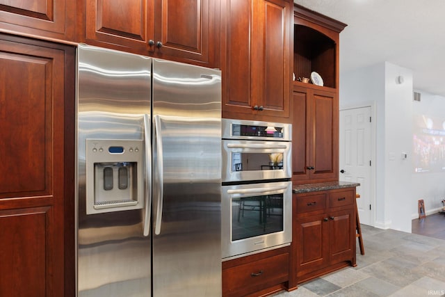 kitchen featuring stainless steel appliances, visible vents, baseboards, open shelves, and dark stone countertops