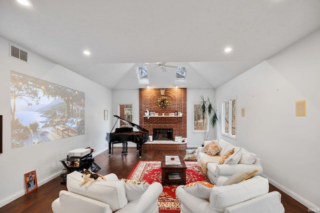 living area with dark wood-style floors, visible vents, vaulted ceiling, and a fireplace