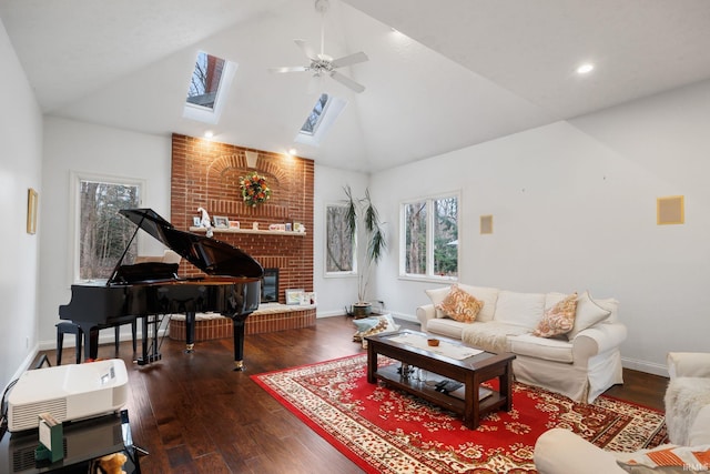 living area with vaulted ceiling with skylight, a fireplace, wood finished floors, and baseboards