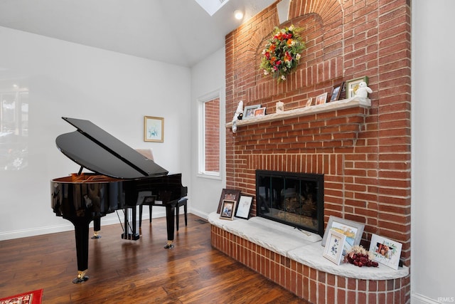 living area with a fireplace, baseboards, and wood finished floors