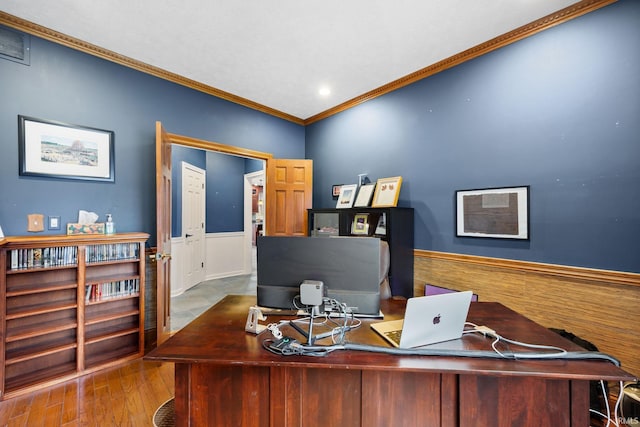 home office with a wainscoted wall, crown molding, visible vents, and wood finished floors