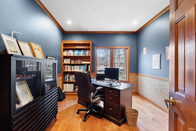 home office featuring light wood-type flooring, wainscoting, and crown molding