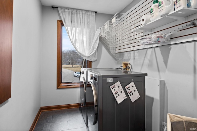 laundry room with laundry area, washer and clothes dryer, tile patterned flooring, and baseboards