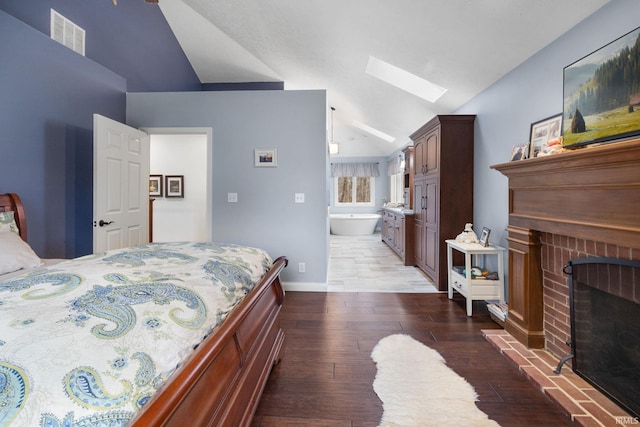 bedroom with baseboards, visible vents, lofted ceiling with skylight, light wood-style floors, and a fireplace