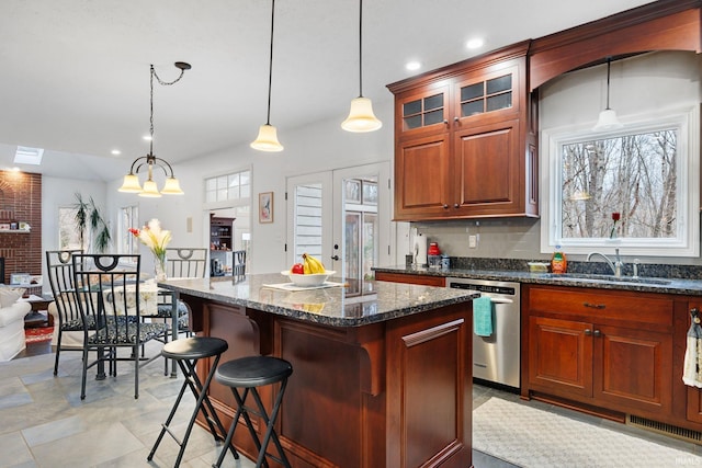 kitchen featuring a brick fireplace, a healthy amount of sunlight, dishwasher, and a sink