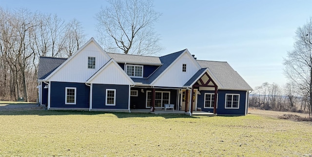 view of front of property with a shingled roof, a front yard, and a patio