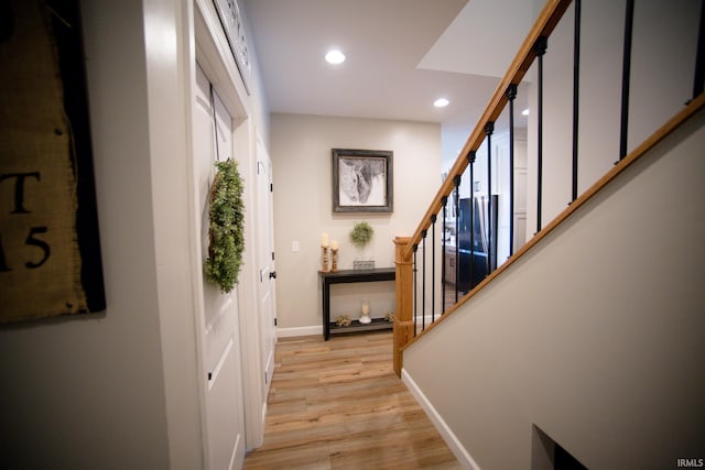 interior space featuring light wood-type flooring, baseboards, recessed lighting, and stairs