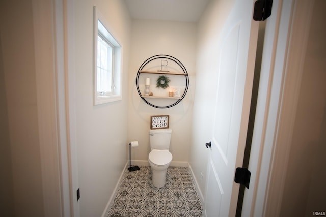 bathroom featuring toilet, baseboards, and tile patterned floors