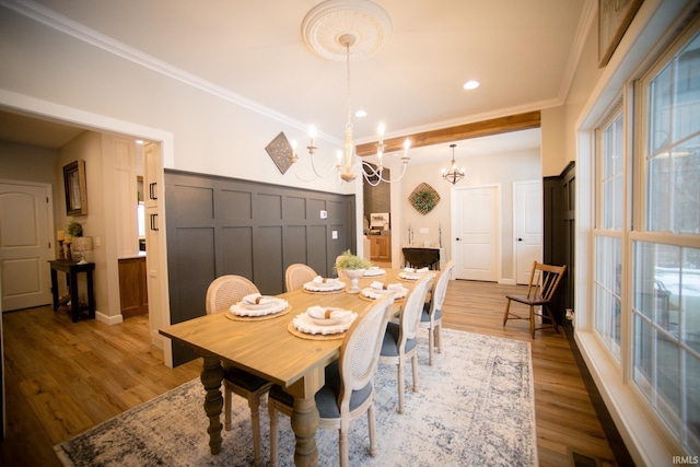 dining space with a notable chandelier, crown molding, recessed lighting, wood finished floors, and baseboards