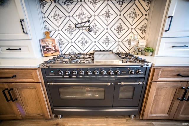 kitchen featuring light countertops, brown cabinets, and double oven range