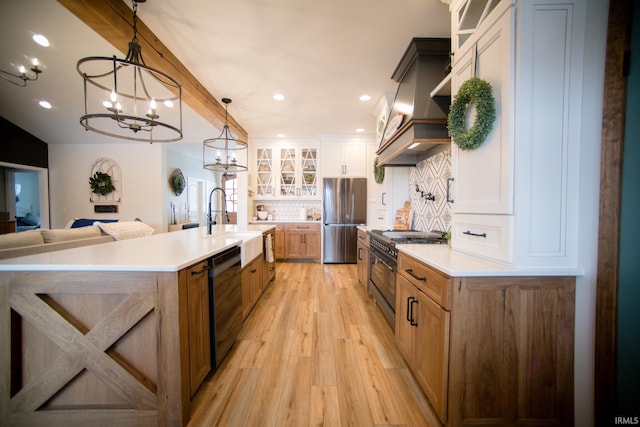 kitchen featuring stainless steel appliances, light countertops, glass insert cabinets, and custom range hood