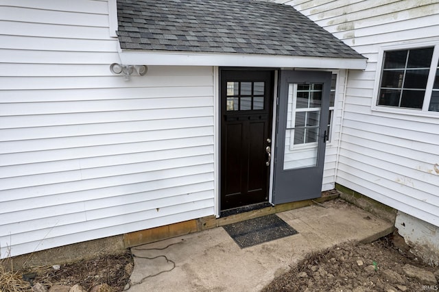 doorway to property with a shingled roof