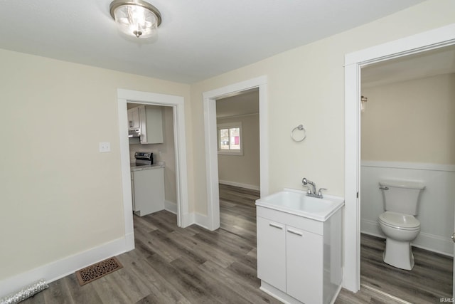 bathroom with wood finished floors, visible vents, and baseboards