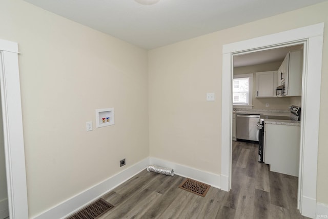 laundry room featuring washer hookup, visible vents, baseboards, and wood finished floors