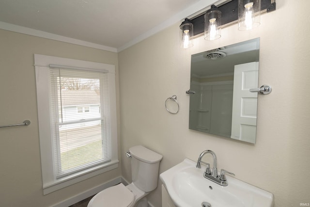 bathroom featuring crown molding, visible vents, toilet, a sink, and baseboards