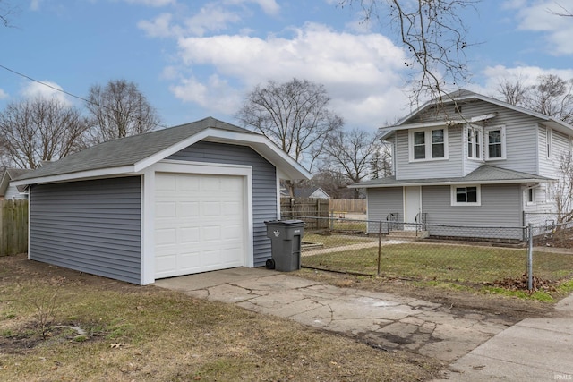 exterior space with a garage, fence, concrete driveway, and an outdoor structure