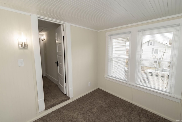 empty room featuring carpet and baseboards