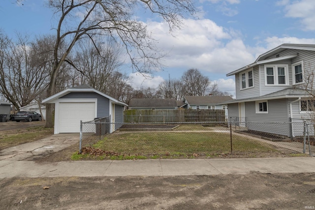 view of home's exterior featuring an outbuilding, a fenced front yard, a garage, concrete driveway, and a lawn