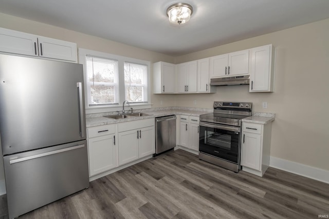 kitchen featuring under cabinet range hood, appliances with stainless steel finishes, white cabinets, and a sink