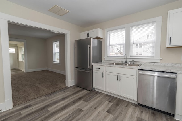 kitchen featuring a healthy amount of sunlight, appliances with stainless steel finishes, light countertops, and a sink