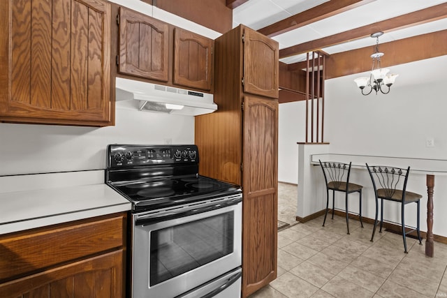 kitchen with brown cabinets, beam ceiling, stainless steel range with electric cooktop, and under cabinet range hood