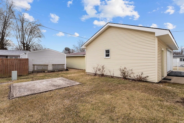 view of side of property featuring a yard, a patio area, and fence