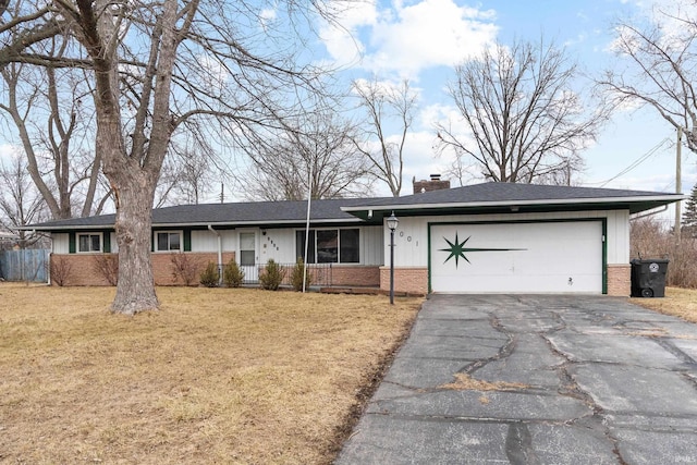 ranch-style home featuring driveway, a front yard, a chimney, and brick siding