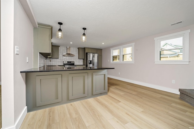 kitchen with gray cabinetry, stainless steel appliances, visible vents, wall chimney range hood, and tasteful backsplash