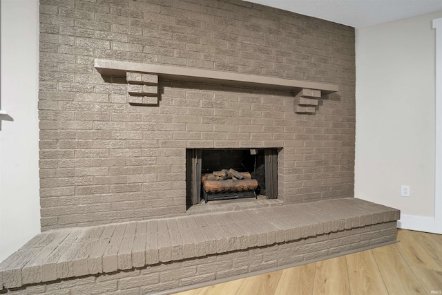 interior details with a fireplace, wood finished floors, and baseboards