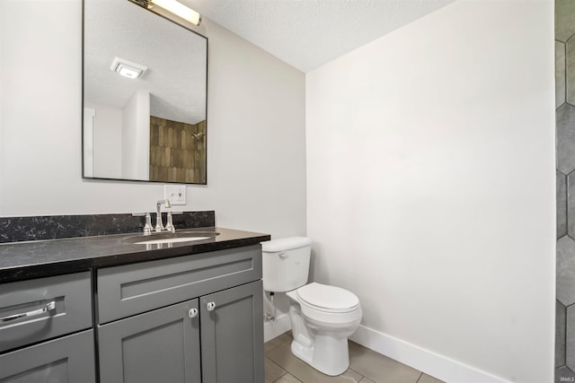 bathroom featuring baseboards, toilet, tile patterned floors, a textured ceiling, and vanity