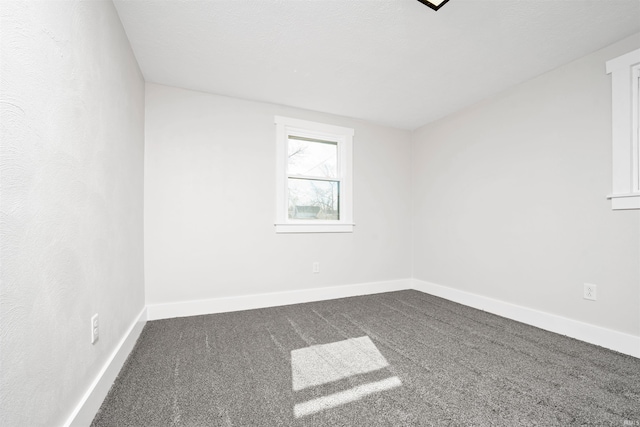 unfurnished room with carpet floors and baseboards