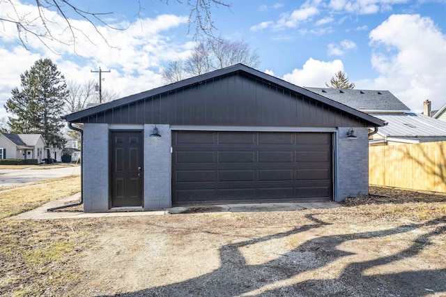 detached garage featuring fence