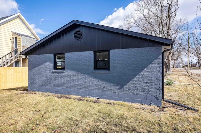 view of side of property with fence and brick siding