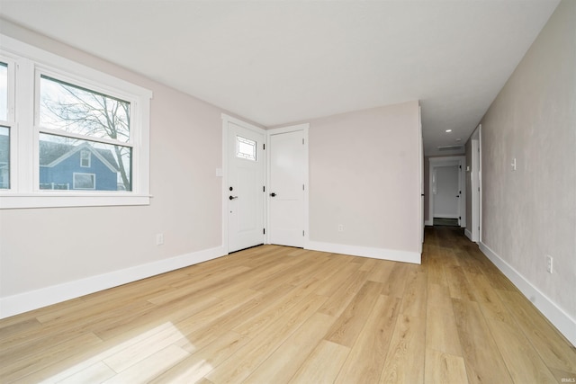 spare room featuring light wood-style floors and baseboards