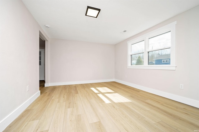 empty room featuring light wood-type flooring and baseboards