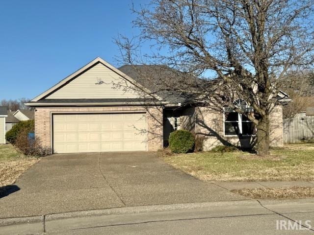 view of front of property with concrete driveway, brick siding, fence, and an attached garage