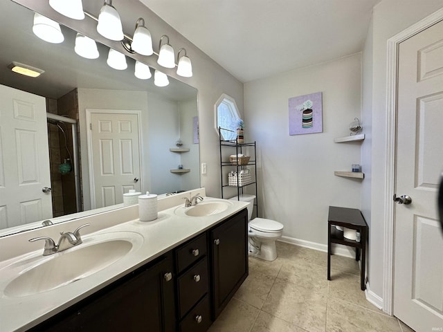 bathroom with baseboards, a sink, a shower stall, and toilet