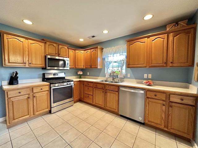 kitchen with stainless steel appliances, light countertops, a sink, and visible vents