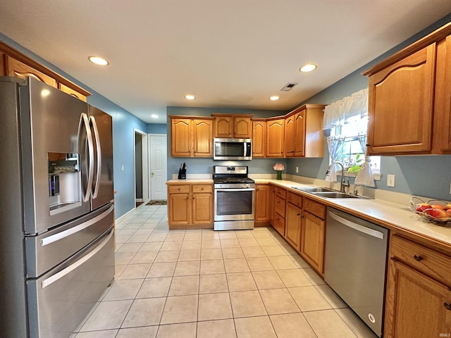 kitchen with appliances with stainless steel finishes, light countertops, visible vents, and a sink