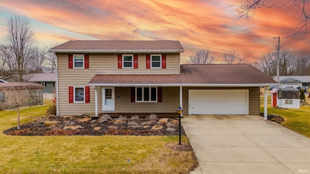 traditional home featuring a garage, a yard, a shingled roof, and concrete driveway