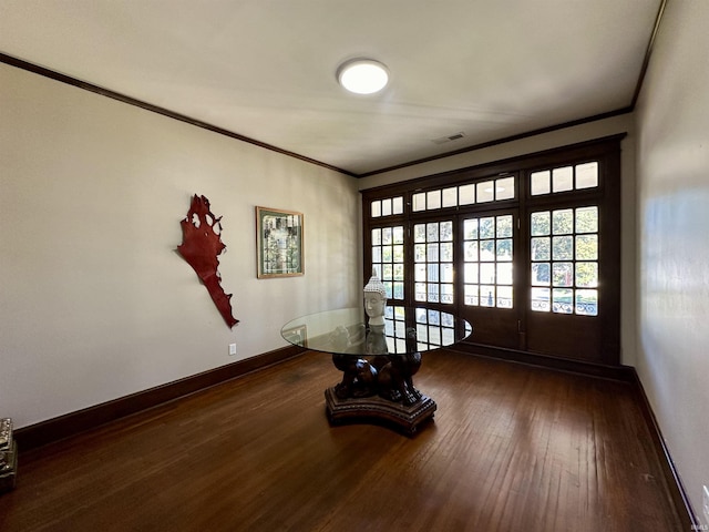 doorway to outside featuring visible vents, crown molding, baseboards, and hardwood / wood-style flooring