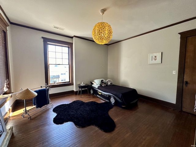 bedroom with ornamental molding, visible vents, baseboards, and wood finished floors