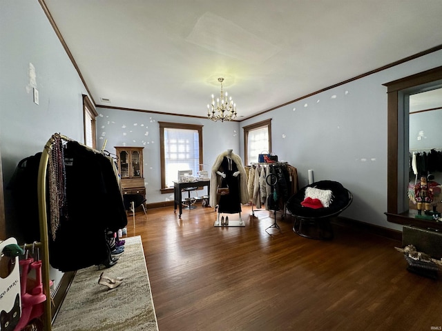 interior space with a notable chandelier, baseboards, wood finished floors, and crown molding