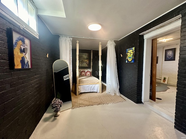 hallway featuring brick wall and concrete flooring