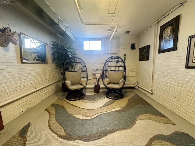 sitting room featuring brick wall