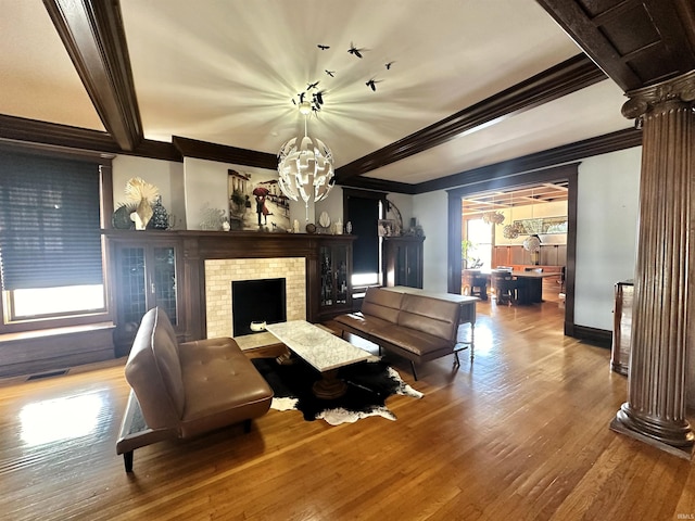 living area with visible vents, a fireplace, beamed ceiling, and wood finished floors