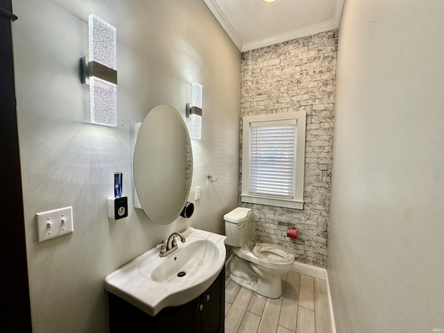 bathroom with toilet, ornamental molding, wood tiled floor, vanity, and baseboards