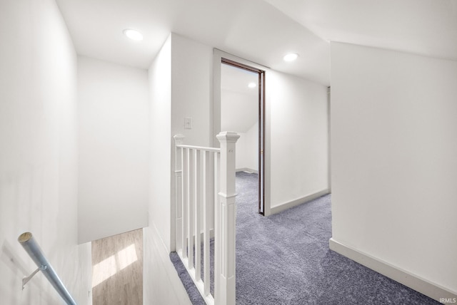 hall with carpet floors, recessed lighting, baseboards, and an upstairs landing