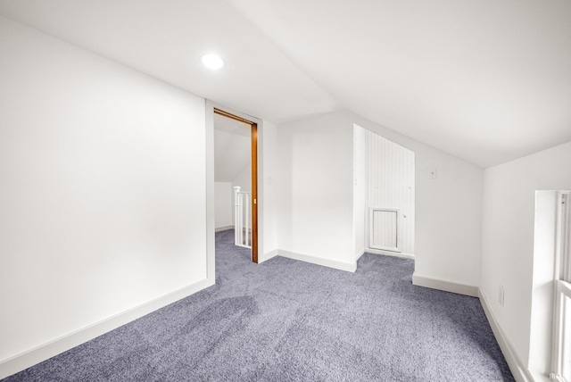 additional living space featuring carpet floors, baseboards, and vaulted ceiling