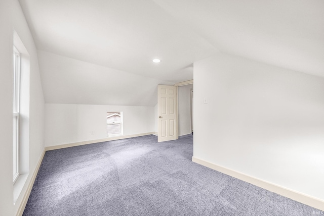 additional living space featuring carpet floors, lofted ceiling, and baseboards